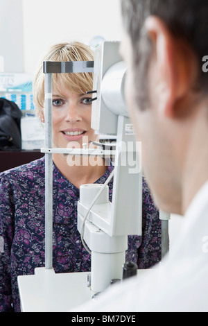 Ein Patient mit einer Spaltlampe Biomicroscope von einem Augenarzt untersucht Stockfoto