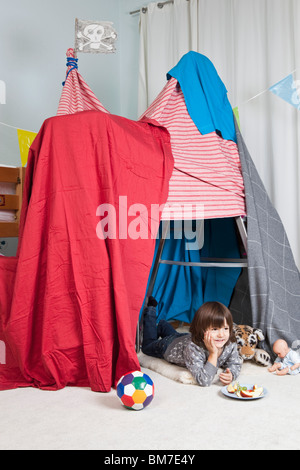 Ein kleiner Junge in einem Fort mit einem snack Stockfoto