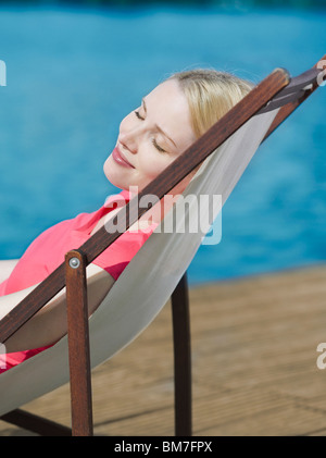 Eine Frau mit ihren Augen geschlossen liegend im Strandkorb Stockfoto