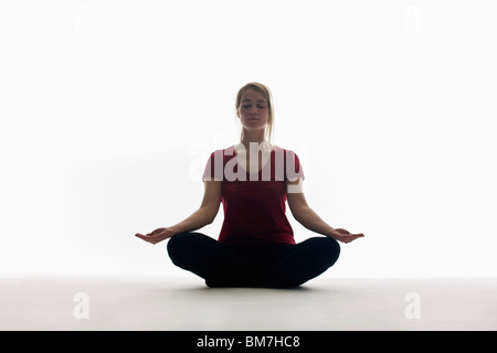 Eine Frau sitzt im Schneidersitz, meditieren Stockfoto