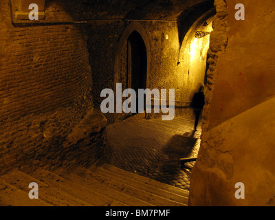 Person, die nachts in dunklen Gasse in Rom Italien Stockfoto