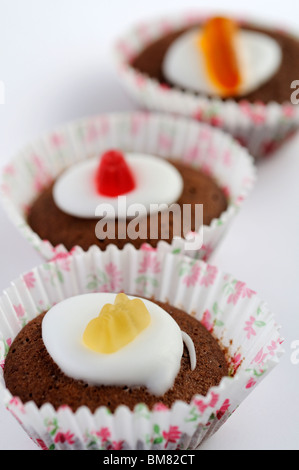 Hausgemachte Mini Schokoladen Cupcakes gekrönt mit Zuckerguss und wigglely Wurm Süßigkeiten. Stockfoto