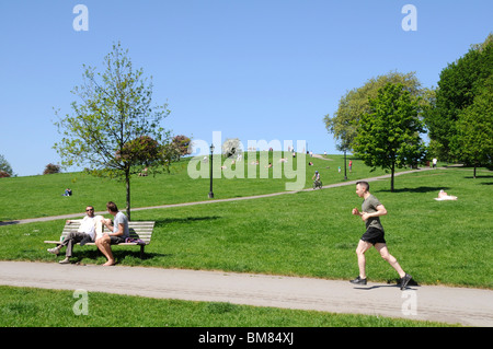 BRITISCHE LEUTE GENIEßEN SONNE IM PRIMROSE HILL PARK IN LONDON CAMDEN Stockfoto