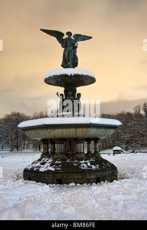 Engel der Wasser oben auf Bethesda Brunnen im Central Park von New York CIty auf einem verschneiten Winterabend. Stockfoto