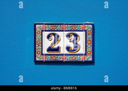 Feinsteinzeug Haus Nummer an Cyan Wand Stockfoto