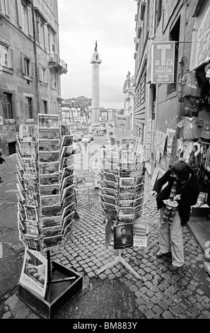 Rom, Italien, 30. Januar 2010--Tourist schaut Postkarten. Trajanssäule in Rom, in schwarz und weiß auf Agfa APX 10 erfasst Stockfoto