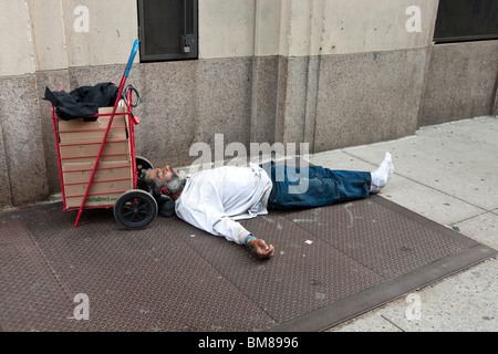 bärtige schwarz Obdachloser tragen Kopfhörer & saubere Kleidung Kurbad zufrieden auf Hells Kitchen Bürgersteig in New York City Stockfoto