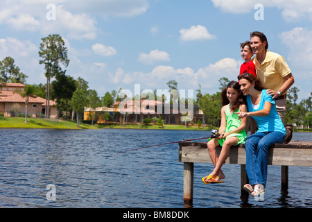 Eine moderne Familie von Mutter, Vater, Kinder, Sohn und Tochter in einem See aus einem Steg an einem sonnigen Tag Angeln Stockfoto