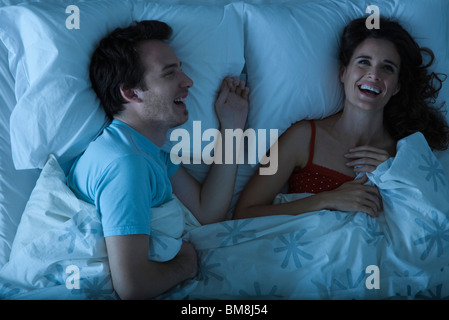 Paar im Bett lachen zusammen liegen Stockfoto