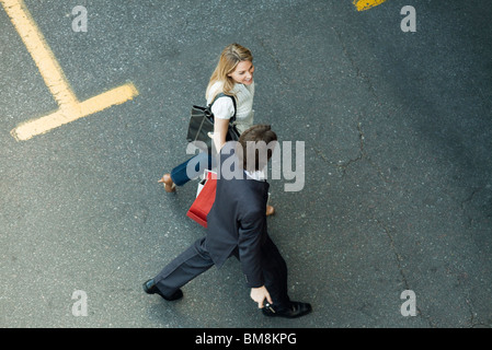 Paare, die zusammen über Parkplatz, Frau Einkaufstaschen tragen Stockfoto