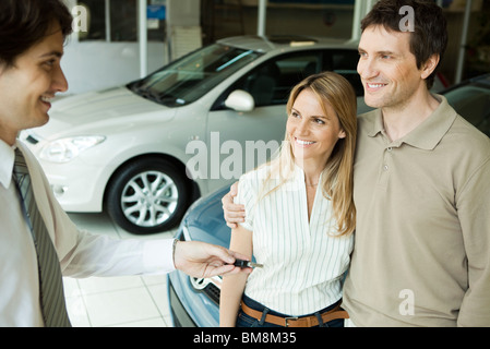 Übergabe der Schlüssel an paar Autoverkäufer Stockfoto