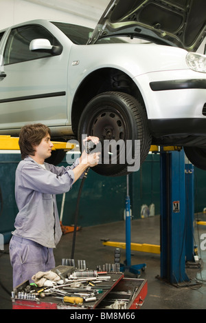 Mechaniker, die Reifen des Autos erhöht auf Hebebühne wechseln Stockfoto