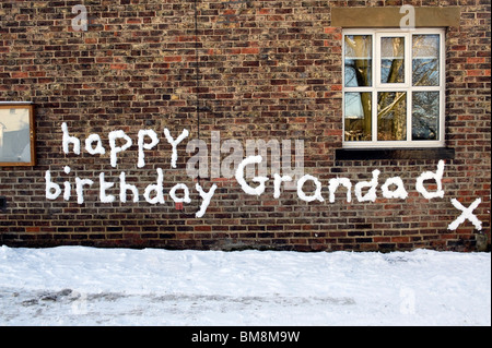 alles Gute zum Geburtstag Opa Nachricht geschrieben im Schnee an Wand in großen Broughton North Yorkshire Stockfoto