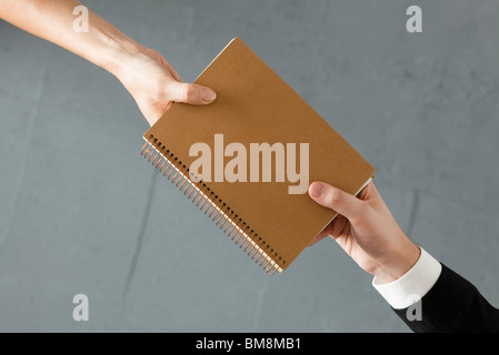 Übergabe der Kollege notebook Stockfoto