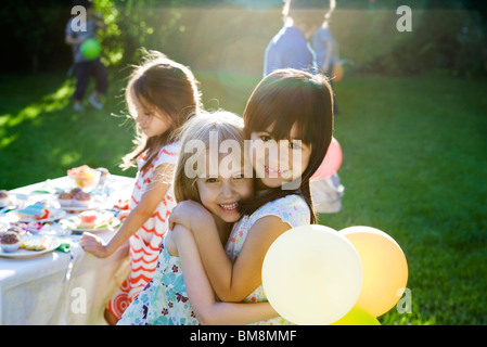 Junge Freunde umarmen auf Outdoor-Party, Porträt Stockfoto