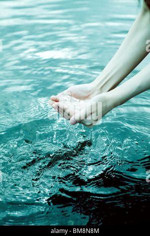 Frau raffte Wasser mit Händen Stockfoto