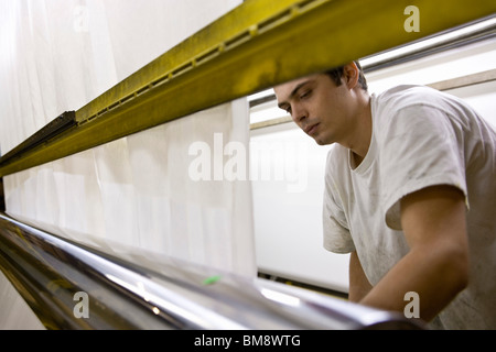 Stoff-Beschichtungsanlage, Maschinist arbeiten auf Fertigungslinie Stockfoto