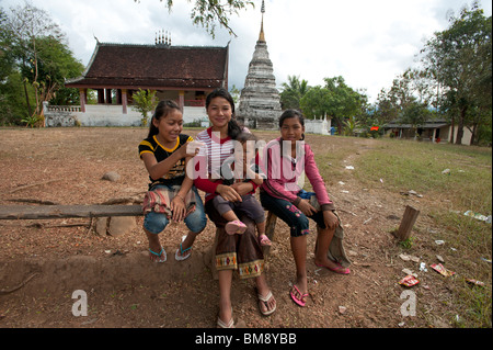 Lao jungen Mädchen und ihren kleinen Bruder auf einer Bank in einem buddhistischen Tempel in Luang Prabang Laos Stockfoto