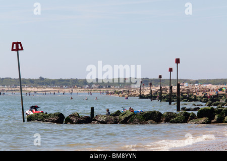 Seetang bedeckt steinerne Buhne Wih roten Marker Pole am Muneford Strand Stockfoto