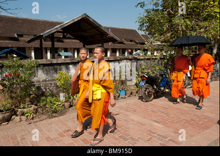 Buddhistische Mönche spazieren Sie durch die Mittagssonne in Luang Prabang Laos Stockfoto