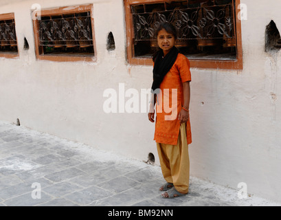 nepalesische Mädchen stand vor betenden Räder, Boudhanath, eine der heiligsten buddhistischen Stätten in Kathmandu, Nepal Stockfoto