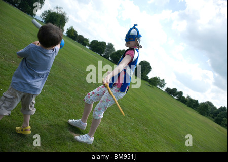 Cousins und Cousinen spielen kämpfen mit Schwertern und Helmen in North yorkshire Stockfoto