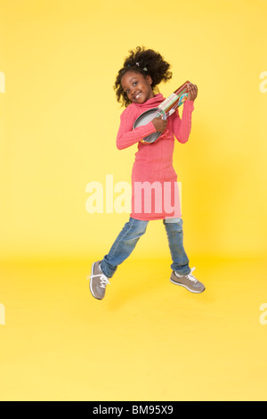 Mädchen spielen mit hausgemachten DIY Handwerk vorgeben machen Musikinstrumente Gitarre glauben Stockfoto