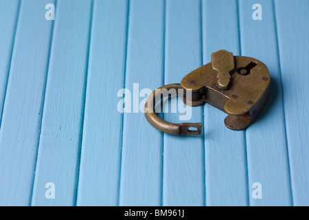Alten altmodischen Vorhängeschloss geöffnet auf einem blauen Hintergrund aus Holz Stockfoto