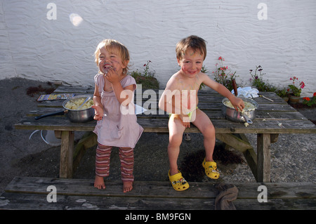 Zwei junge Kinder lachen miteinander im Urlaub in Cornwall, England, UK Stockfoto