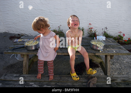 Zwei junge Kinder lachen miteinander im Urlaub in Cornwall, England, UK Stockfoto