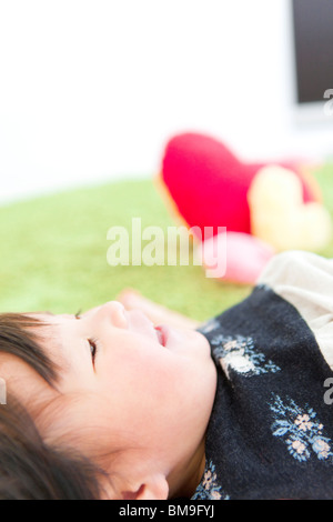 Babymädchen auf Rücken liegend Stockfoto