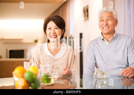 Senior paar Tee trinken am Esstisch, lächelnd Stockfoto