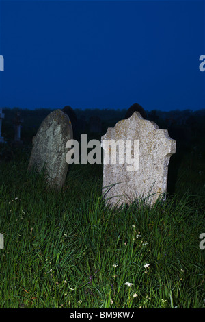 Grabsteine in einer nebligen Nacht in der Abenddämmerung. Stockfoto