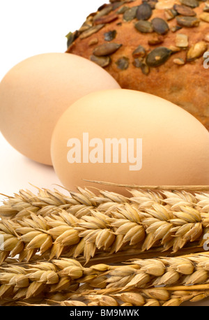 Stillleben mit Ohren von Weizen, Ei und Weißbrot Stockfoto