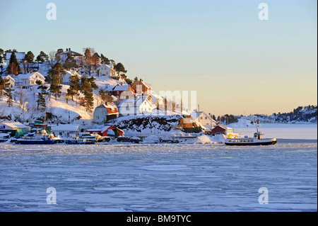 Blick über den gefrorenen Hafen von Arendal mit Blick auf die Insel Skilsoy, einer kleinen Insel in der Nähe von Tromoy Stockfoto