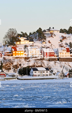 Blick über den gefrorenen Hafen von Arendal mit Blick auf die Insel Skilsoy, einer kleinen Insel in der Nähe von Tromoy Stockfoto