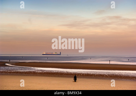 Antony Gormleys "Woanders" Crosby Strand Merseyside. Ansicht der Schifffahrt am Horizont. Stockfoto