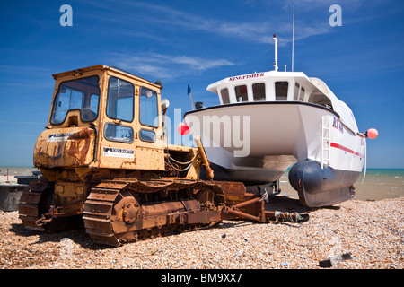 Twin Hull Fischerboot und Caterpillar verfolgt Traktor auf Dungeness Strand Stockfoto