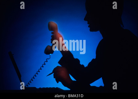 Business-Frau im Büro in der Nacht, mit Handy und Laptop-Computer. Stockfoto