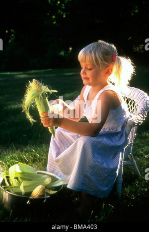 Junges Mädchen am Mais. Stockfoto