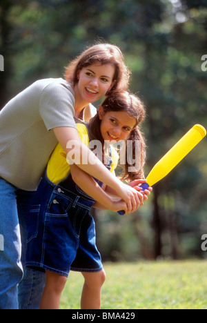 Frau zeigt ihre Tochter wie eine Fledermaus im Baseball zu verwenden. Stockfoto
