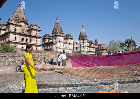 Inder Trocknung Saris nach dem Baden im Fluss Petwa. Im Hintergrund die königliche Ehrenmale. Orchha. Indien Stockfoto