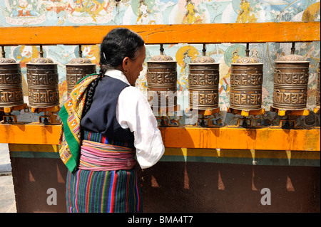 tibetische Flüchtlinge drehen die Gebetsmühlen in Boudhanath, eine der heiligsten buddhistischen Stätten in Kathmandu, Nepal Stockfoto