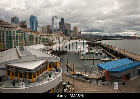 Die dramatische Skyline von Seattle, Washington als gesehen vom Pier 66 an der Elliott Bay Waterfront. Marinas, Restaurants am Wasser. Stockfoto