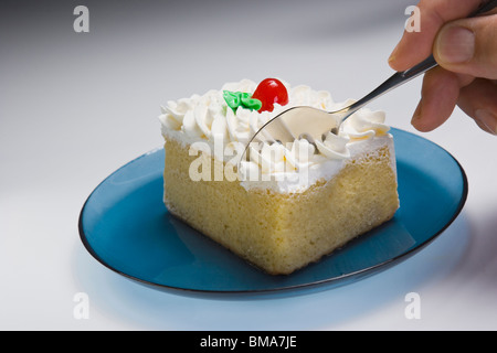 Mann isst Tres Leches Kuchen mit einem Löffel, Nahaufnahme Stockfoto