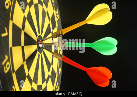 Drei bunte Darts in der Bullseye. Stockfoto