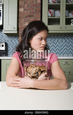 Junge Frau mit Keksdose Stockfoto