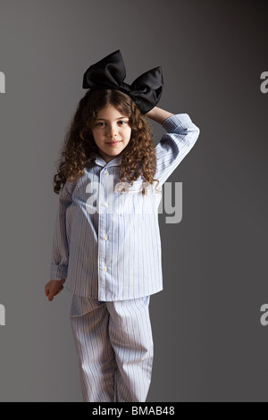 Junge Mädchen im Schlafanzug mit schwarzen Haaren Bogen Stockfoto