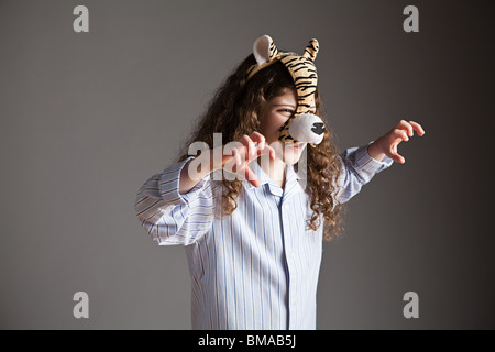 Junge Mädchen tragen Tigermaske, brüllen Stockfoto