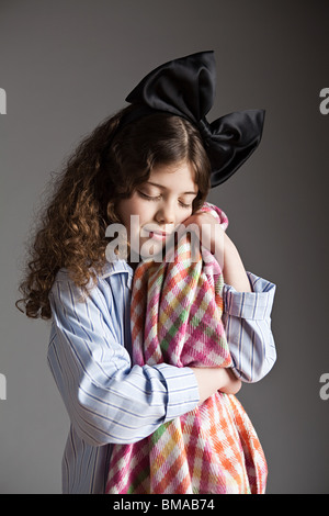 Junges Mädchen gekleidet im Pyjama mit schwarzen Haaren Bogen halten Schmusedecke Stockfoto